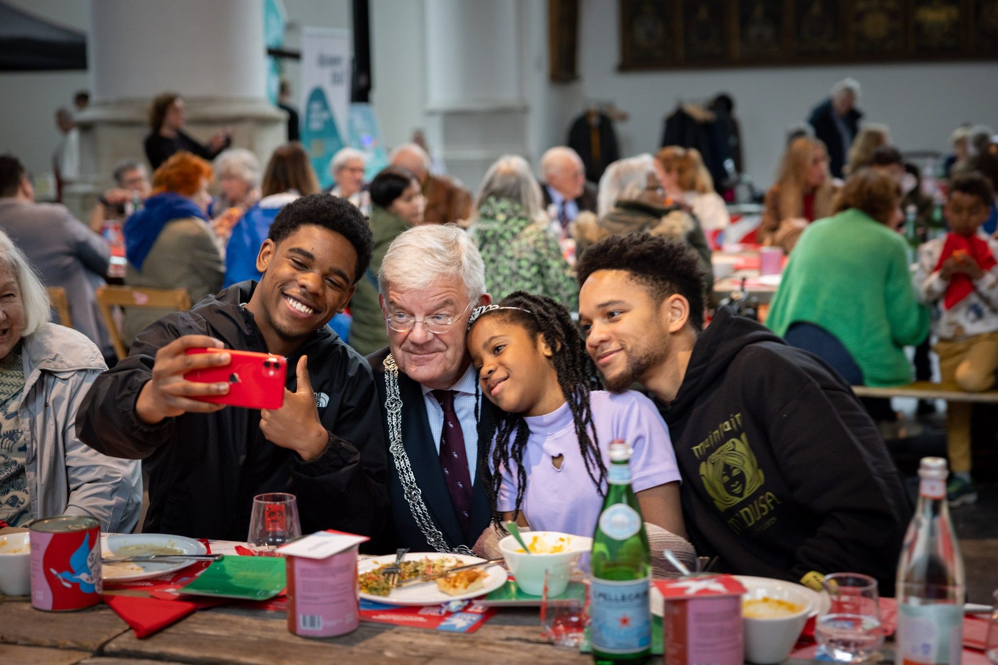 Bezoekers maken een selfie samen met burgemeester Jan van Zanen tijdens de Haagse Vrijheidsmaaltijd. Foto Anne Reitsma Fotografie
